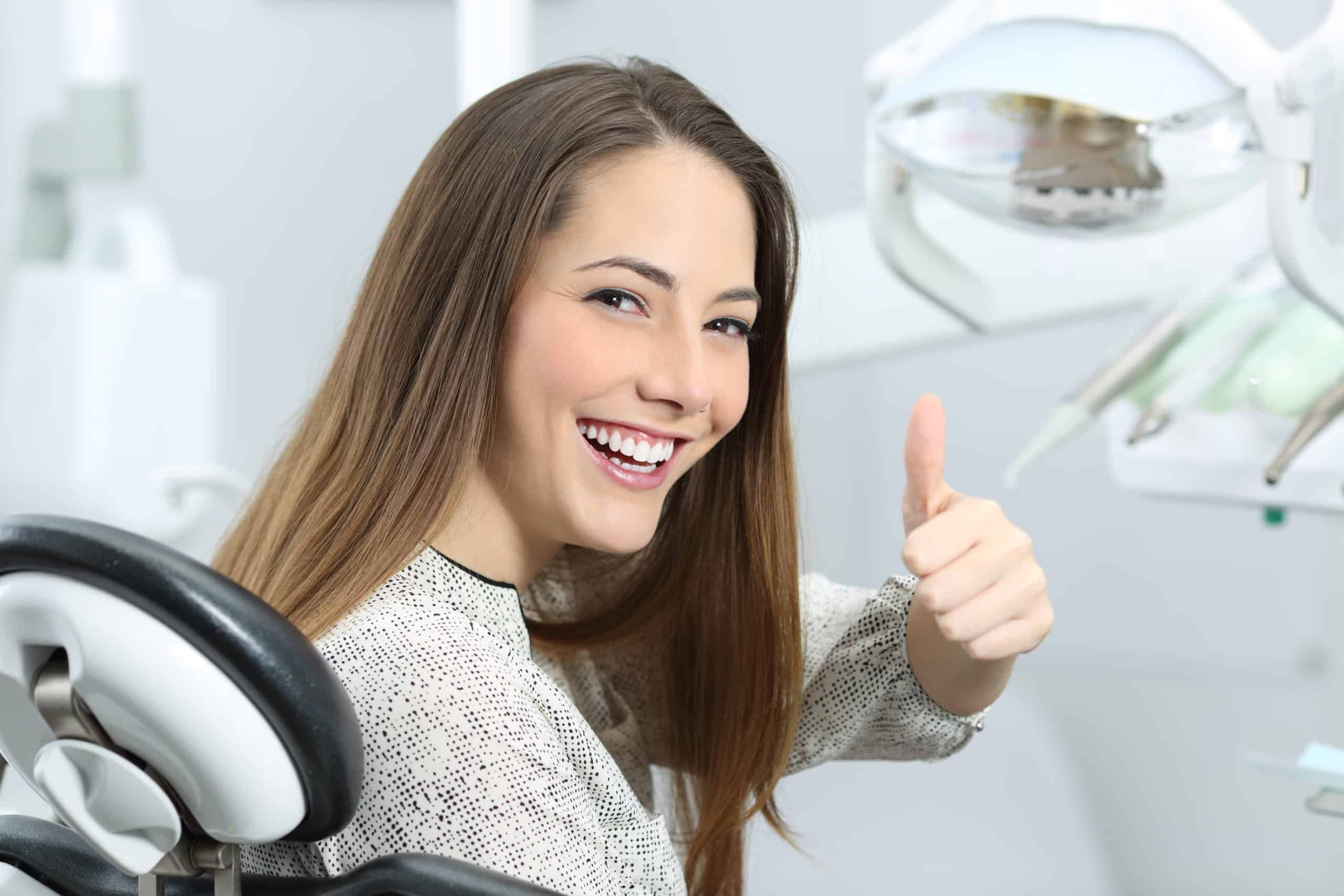 woman giving a thumbs up at the dentist